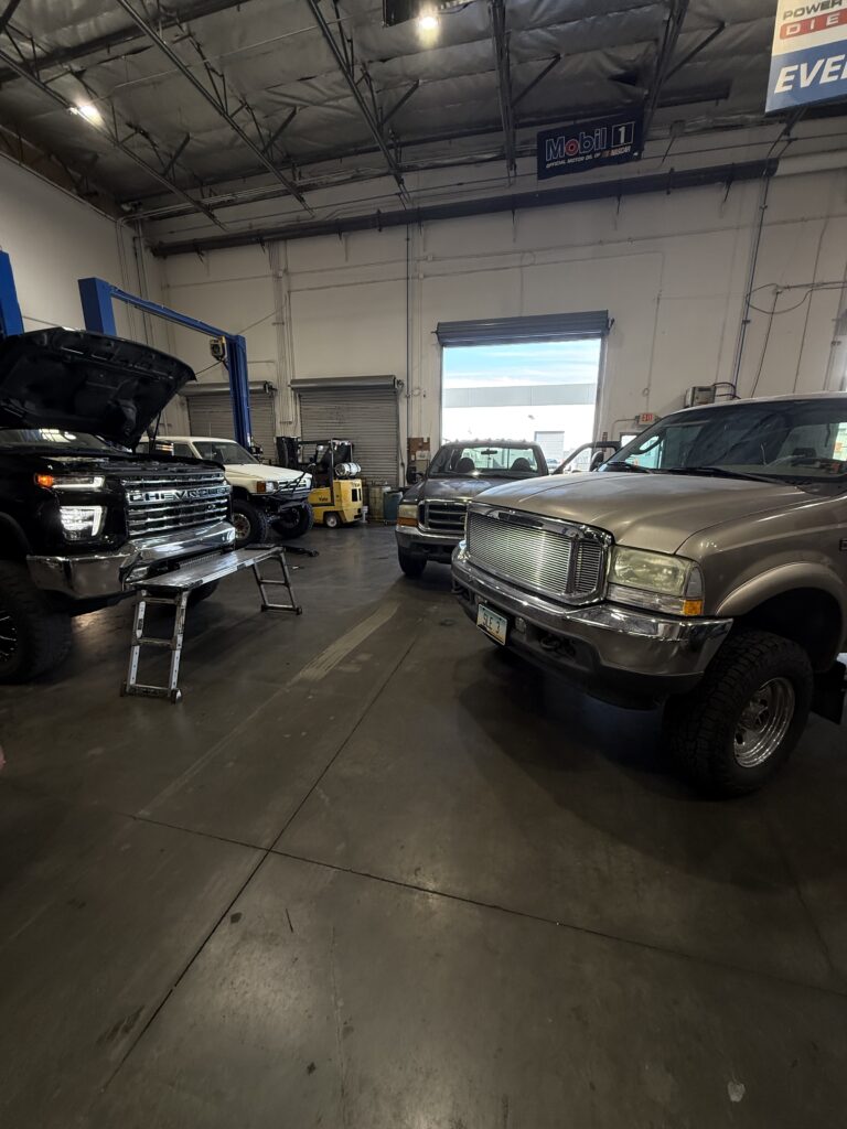 Cars waiting for an auto oil leak repair in a mechanic shop.